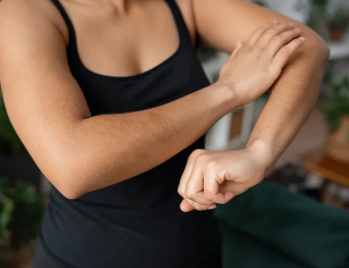Mujer sujetándose el codo por dolor