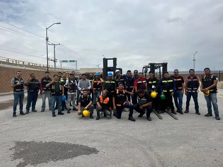Grupo de participantes del curso de montacargas en el patio de maniobras
