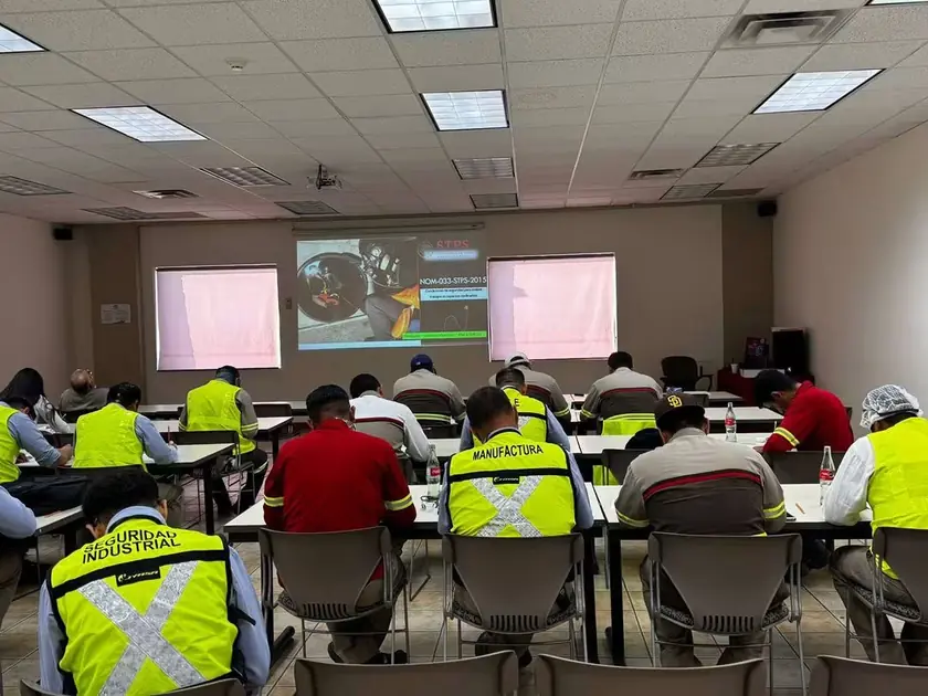 Trabajadores de planta en un curso de capacitación con proyector